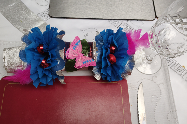 blue and silver christmas cracker with a pink butterfly decoration