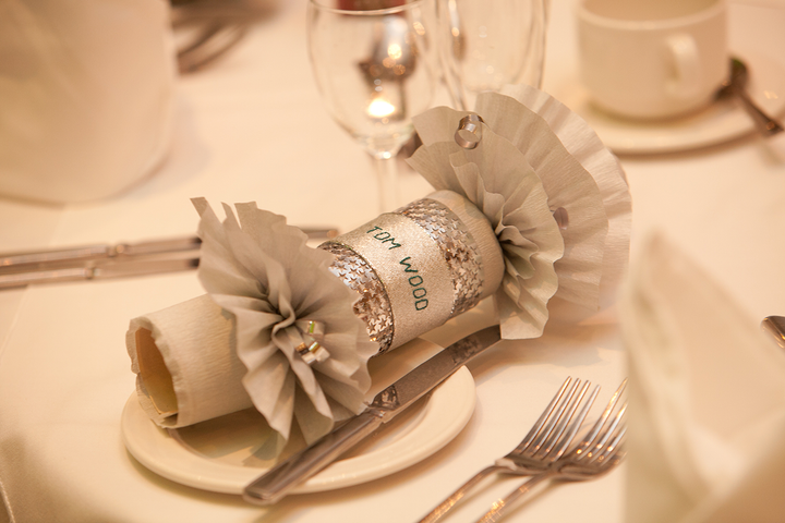 silver crackers with a name for a wedding place setting